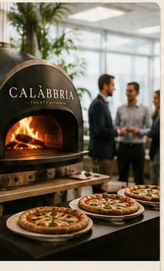 Wood-fired oven set up in an office space, colleagues chatting nearby
