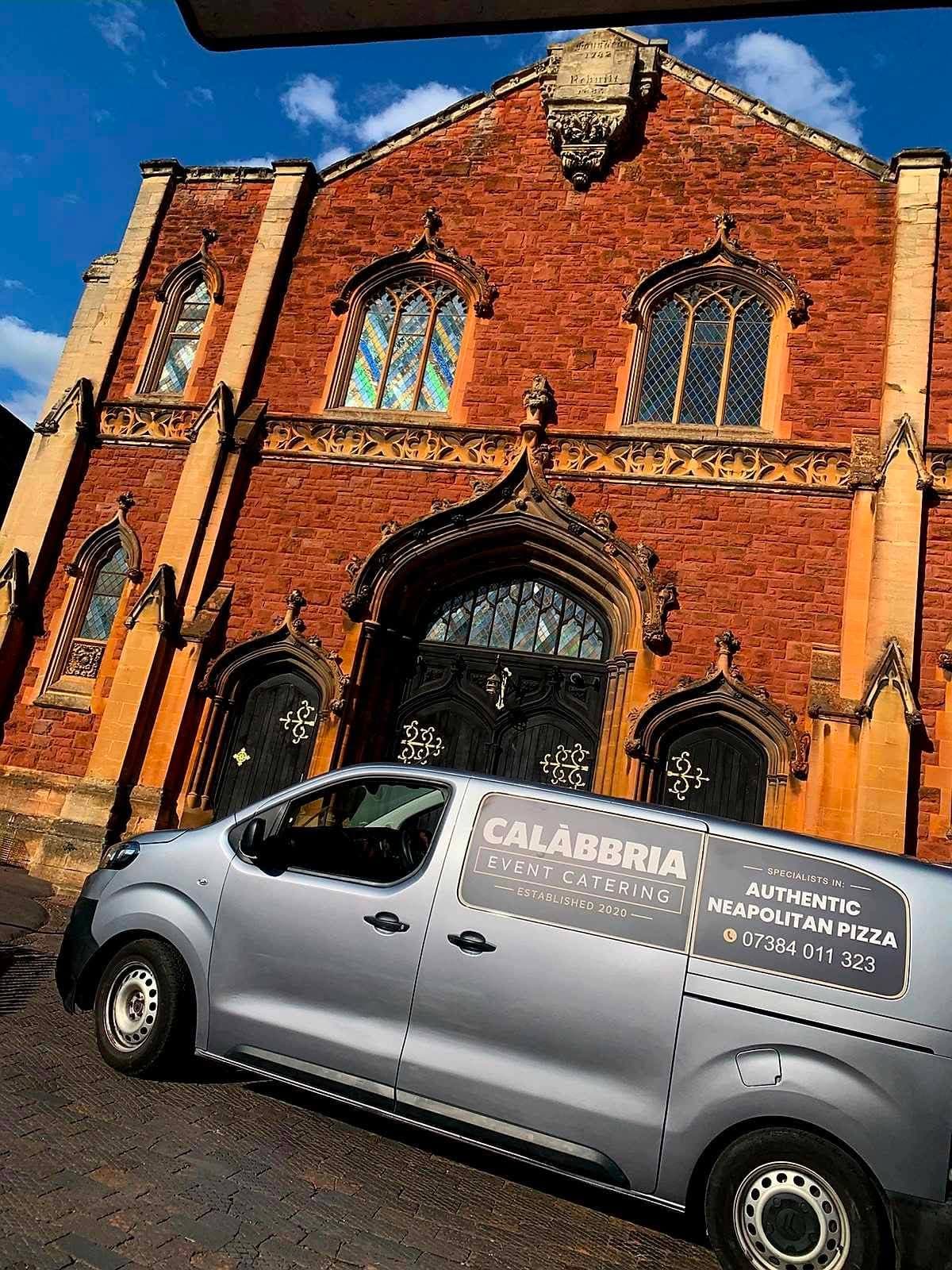 Calàbbria catering van parked outside a historic building